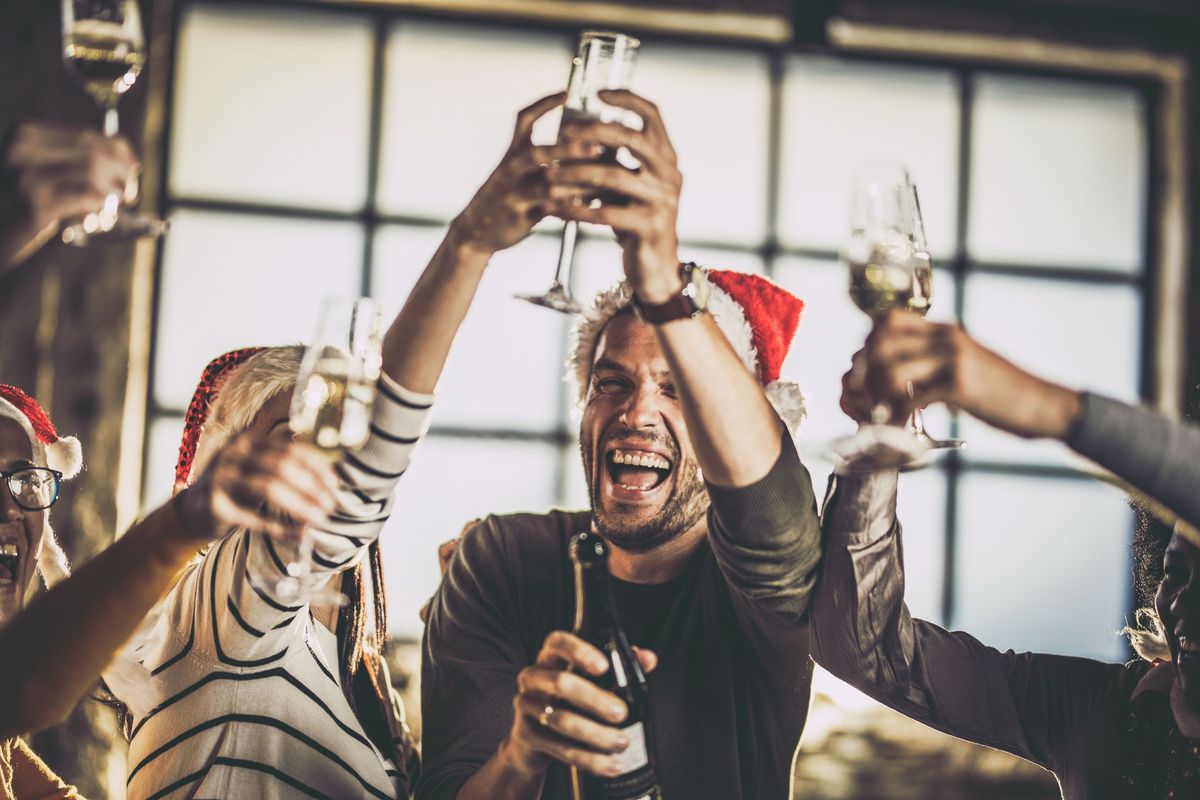 Grupo de colegas alegres brindando por el año nuevo en una fiesta en la oficina